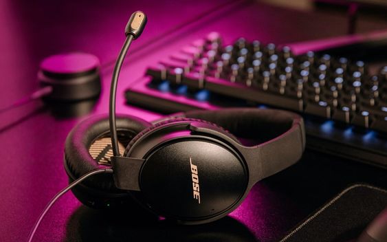 bose-headphone- Quiet Comfort 35 II headphones on a gaming desk – the best noise-canceling headphones for music and gaming. 